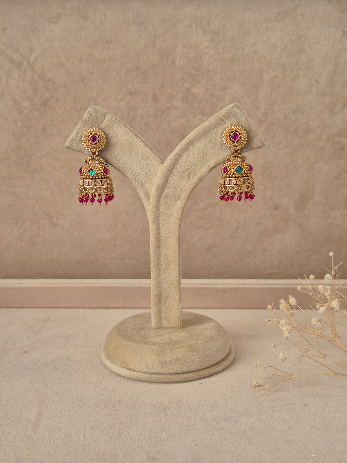 Pratibha handcrafted gold-finish jhumka earrings with ruby and green stone accents by naitri.in