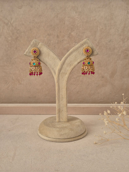Pratibha handcrafted gold-finish jhumka earrings with ruby and green stone accents by naitri.in