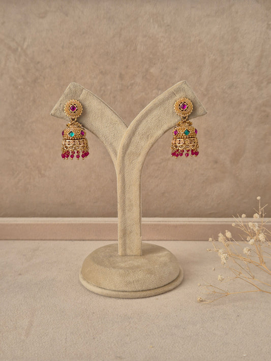 Pratibha handcrafted gold-finish jhumka earrings with ruby and green stone accents by naitri.in