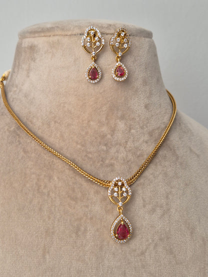 Gold jewelry set with red gemstones handcrafted drop shaped piece attached with leaf shaped pendant 