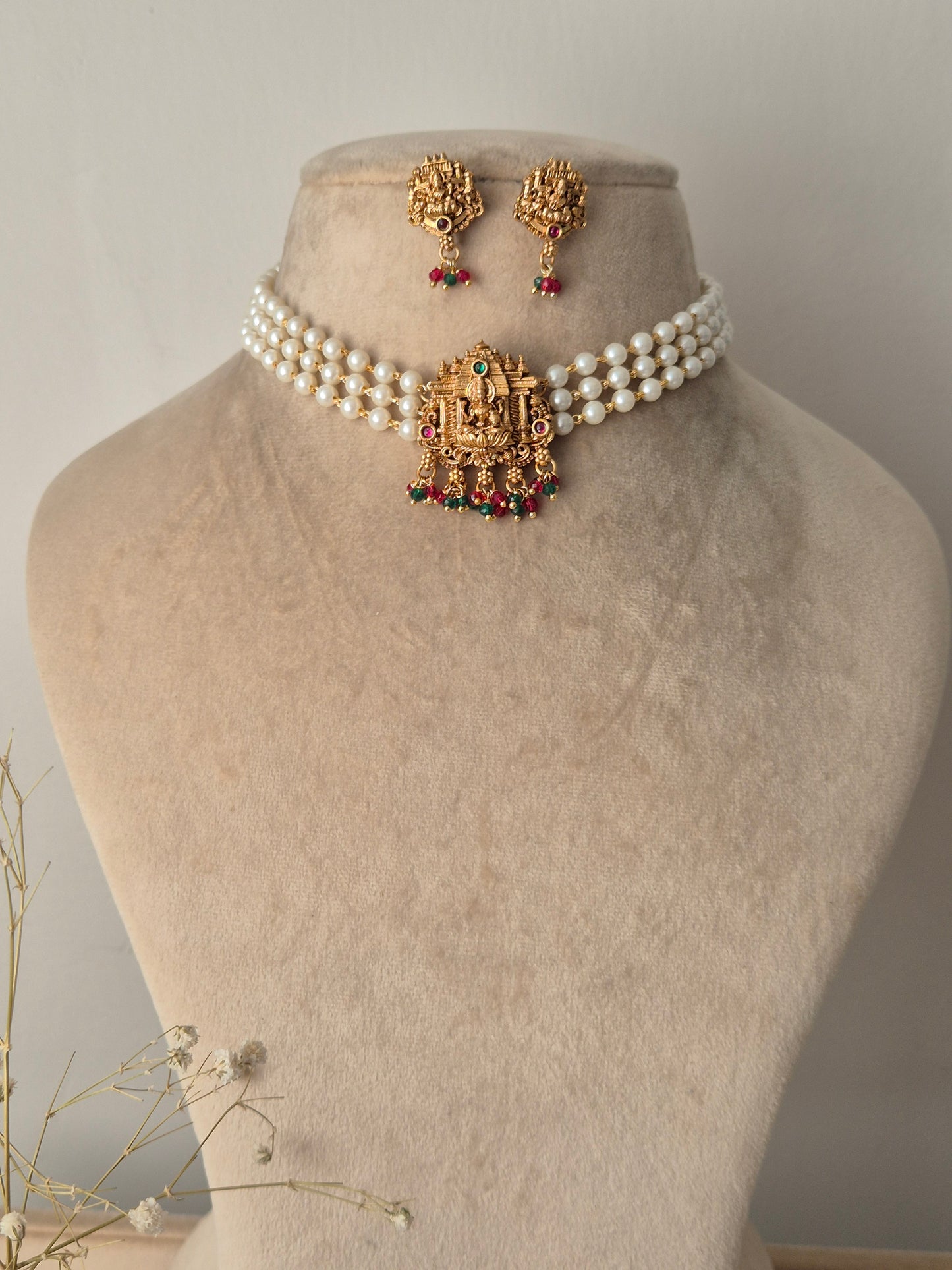 Set of gold jewelry with pearls chain, central motif representing purity and enlightenment, often used as a throne for the goddess by naitri.in