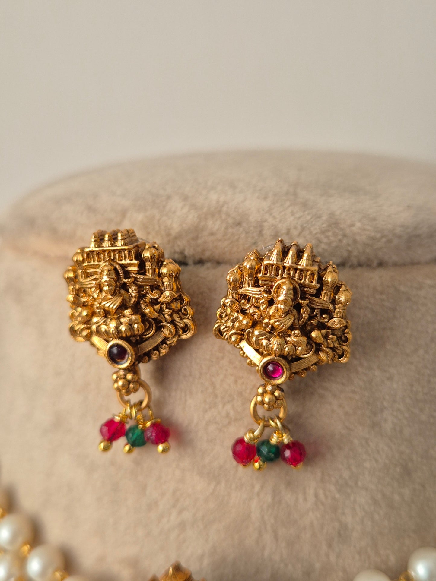 Gold earrings with intricate designs and colorful beads by naitri.in
