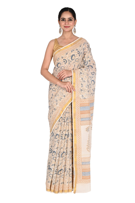 Woman wearing the Punya hand block printed cotton saree in white with blue floral motifs and a beige geometric border by naitri.in