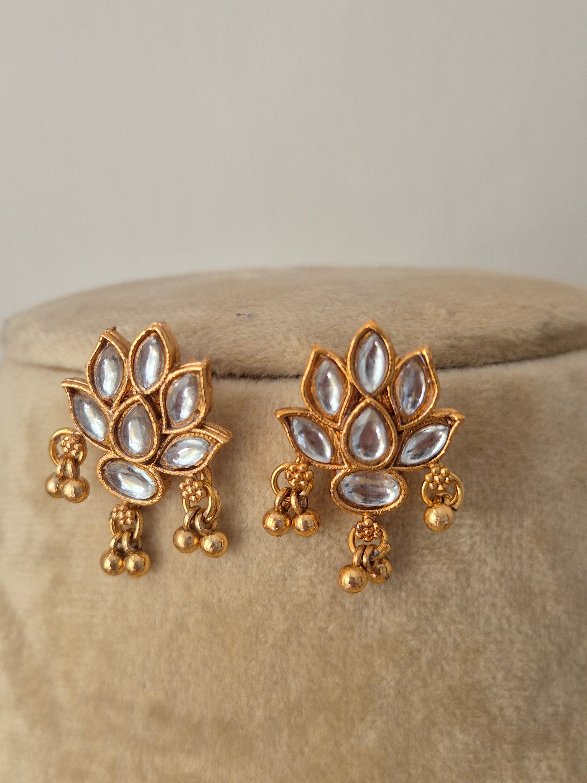 Artisanal Qaynat earring set in a modern Indian ethnic aesthetic, intricate floral carvings, white stone accents, and coordinating festive earrings by naitri.in