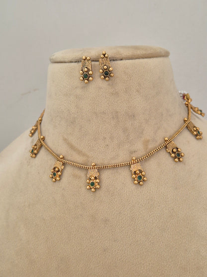 Quhu Necklace Set by Naitri featuring an ethnic gold-plated choker with green stone floral motifs for festive wear by naitri.in