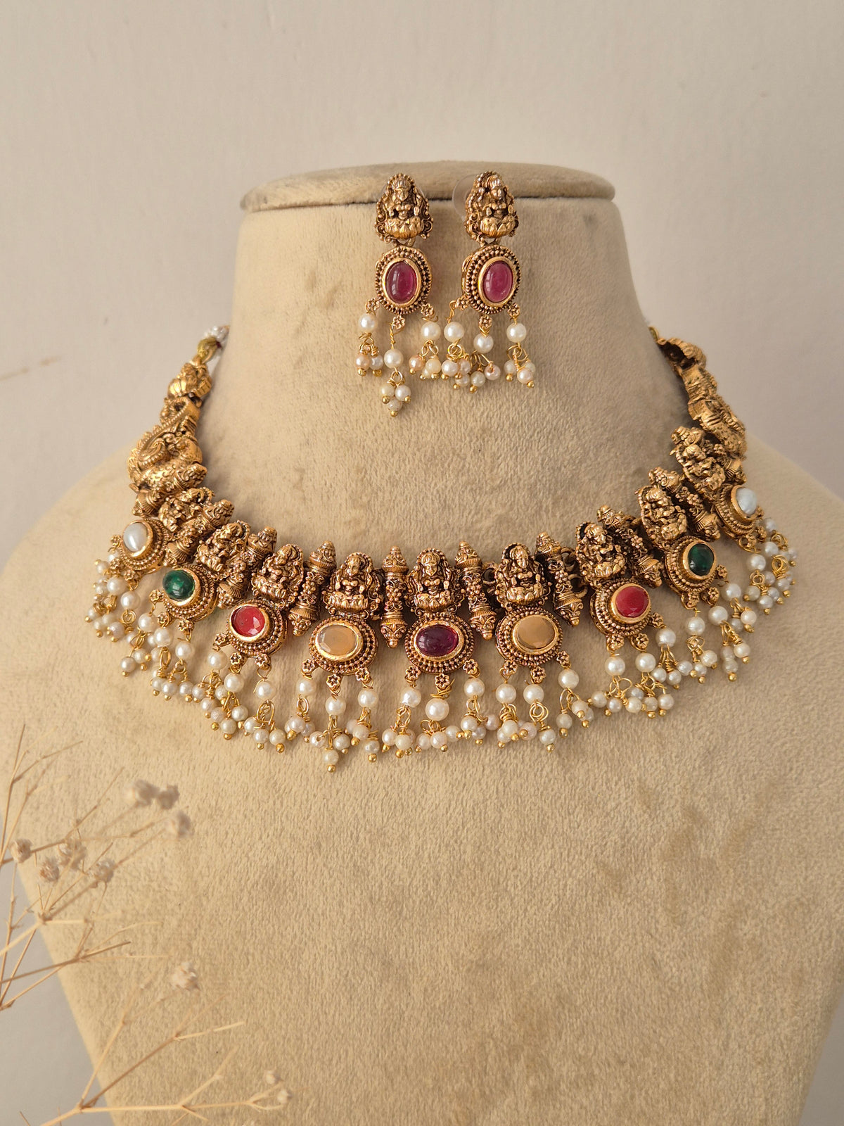 Handcrafted Golden Antique Jewelry Set featuring an elaborate choker necklace and matching stud earrings designed with traditional motifs, perfect for weddings and festive occasions by Naitri.in