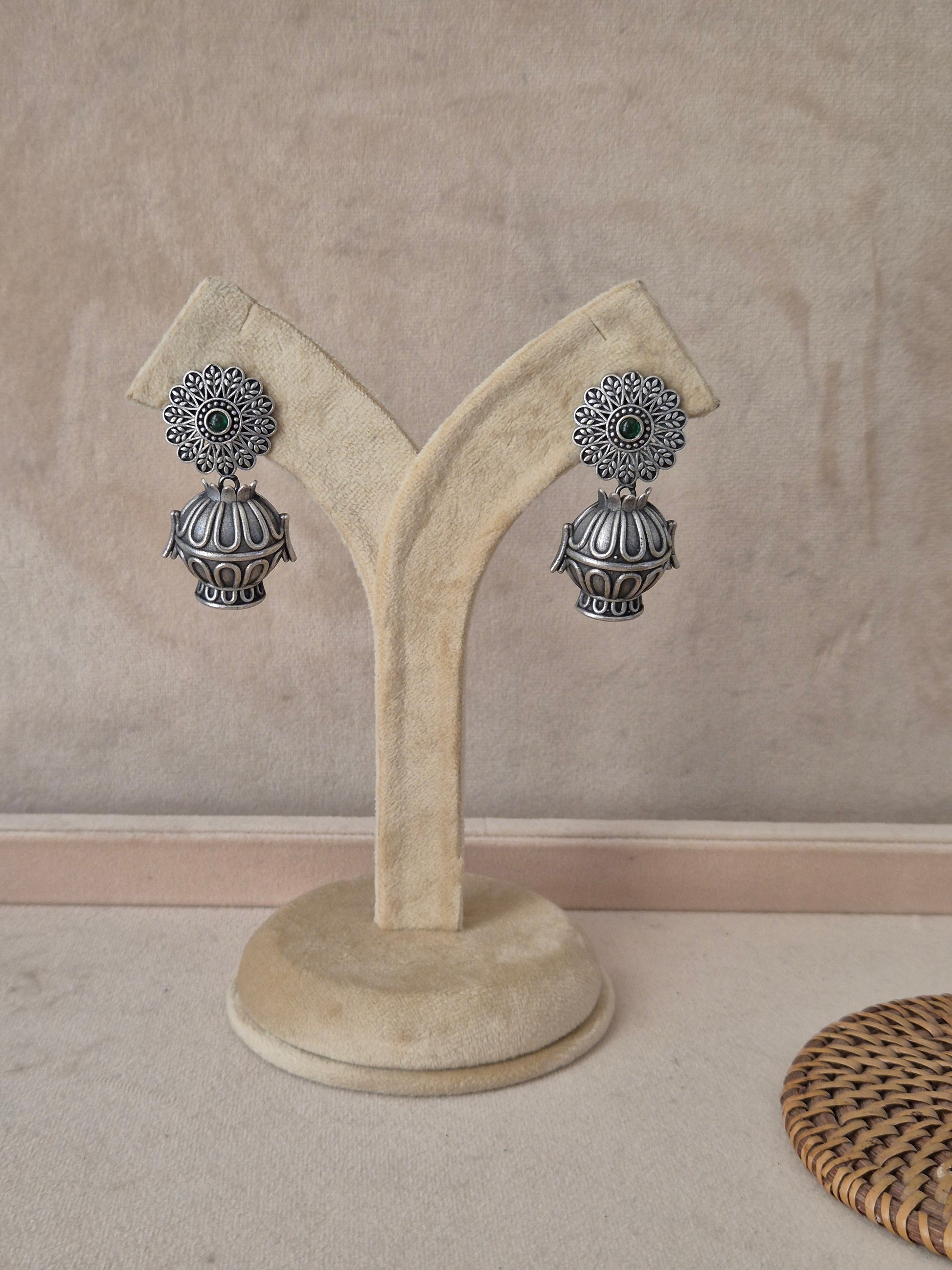 Pair of Rangoli oxidized silver jhumka earrings with intricate mandala-style floral studs by naitri.in