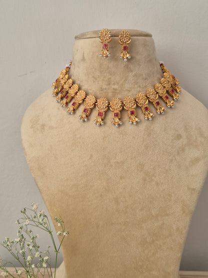 Antique gold choker necklace with matching drop earrings and small red gemstones with matching earrings by naitri.in