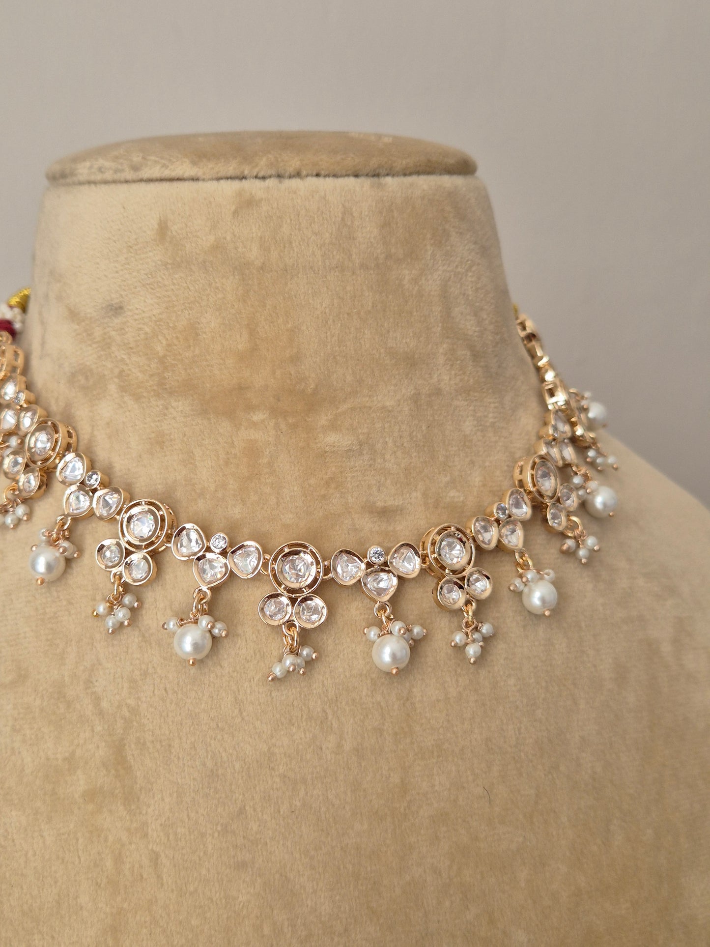 Rose-Gold toned floral choker necklace and matching earrings adorned with clear diamonds and white pearls by naitri.in