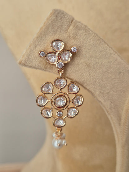 Close-up of a floral design American diamond necklace with teardrop pearl accents and a polished gold finish by naitri.in