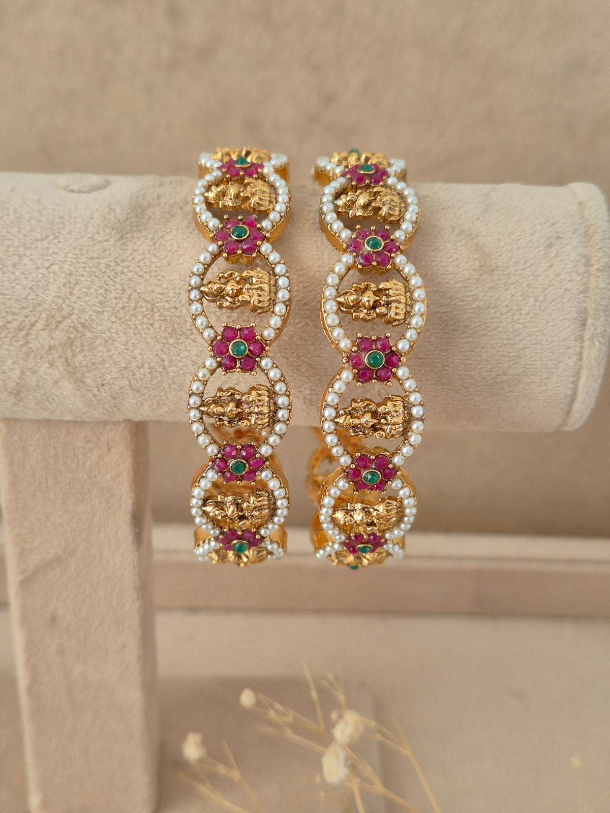 Set of two traditional stone and pearl studded gold-plated bangles by naitri.in