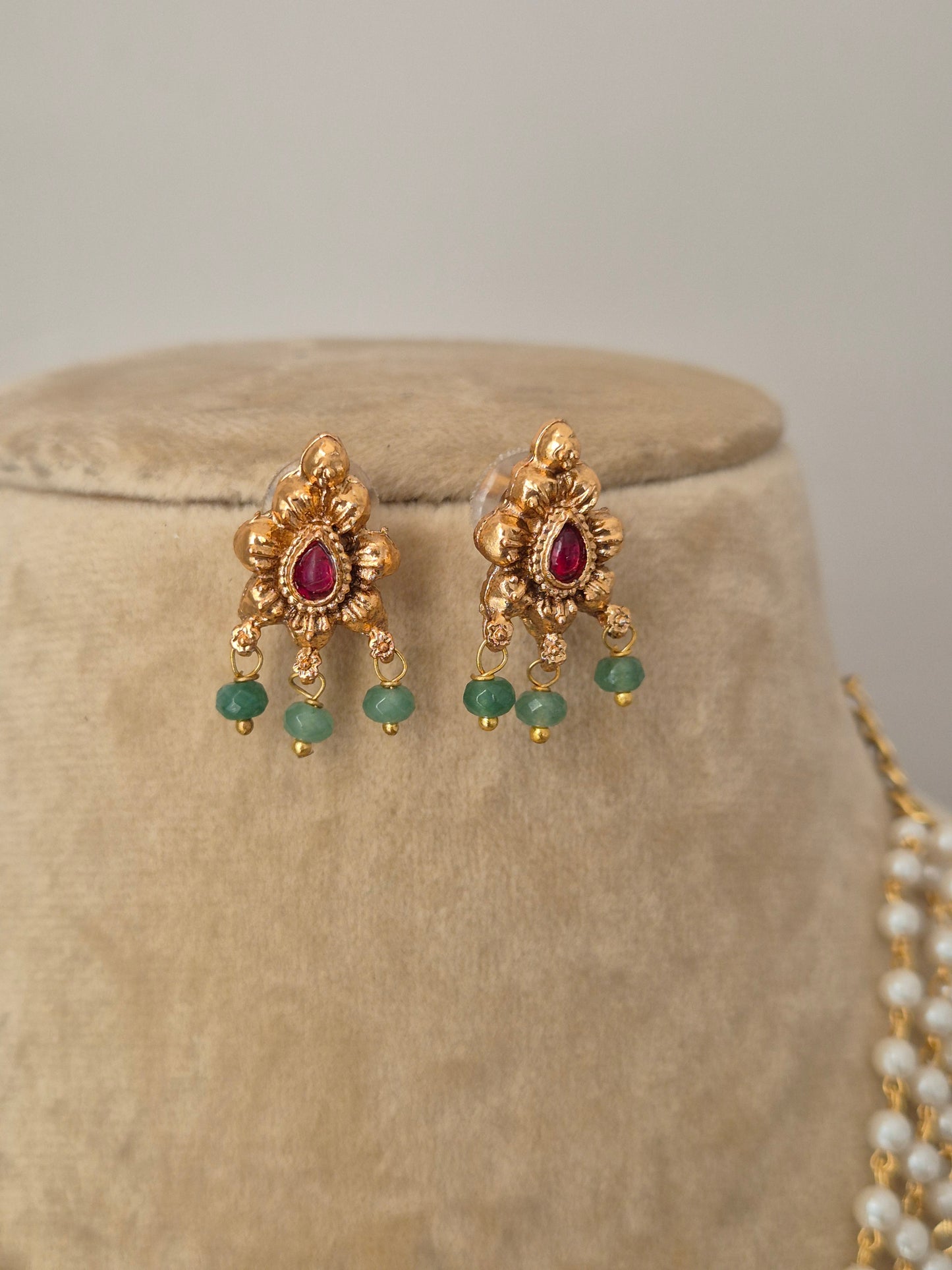 Traditional Indian ethnic necklace set with a white pearl chain, floral gold pendant, and matching stud earrings by naitri.in