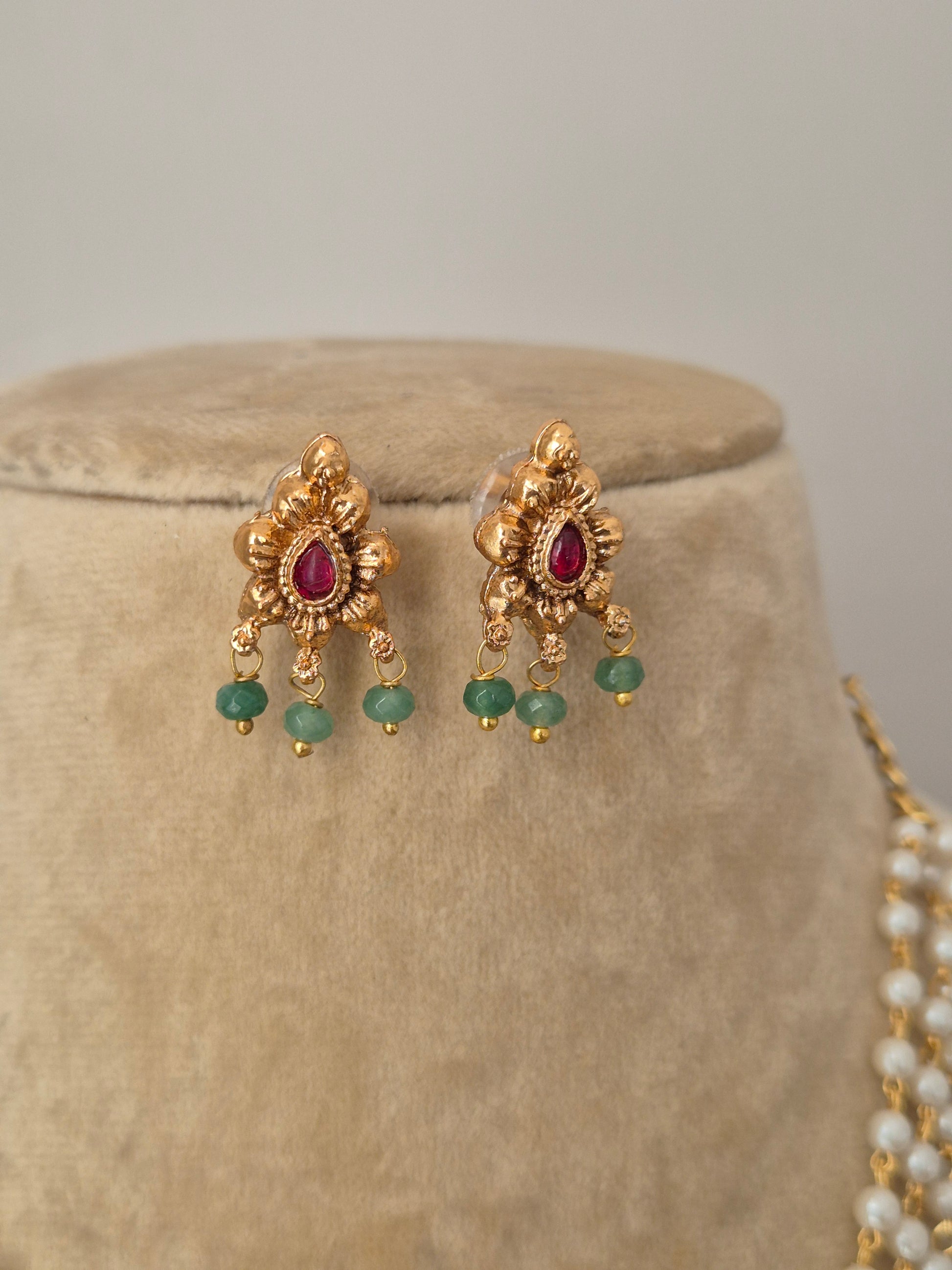 Traditional Indian ethnic necklace set with a white pearl chain, floral gold pendant, and matching stud earrings by naitri.in