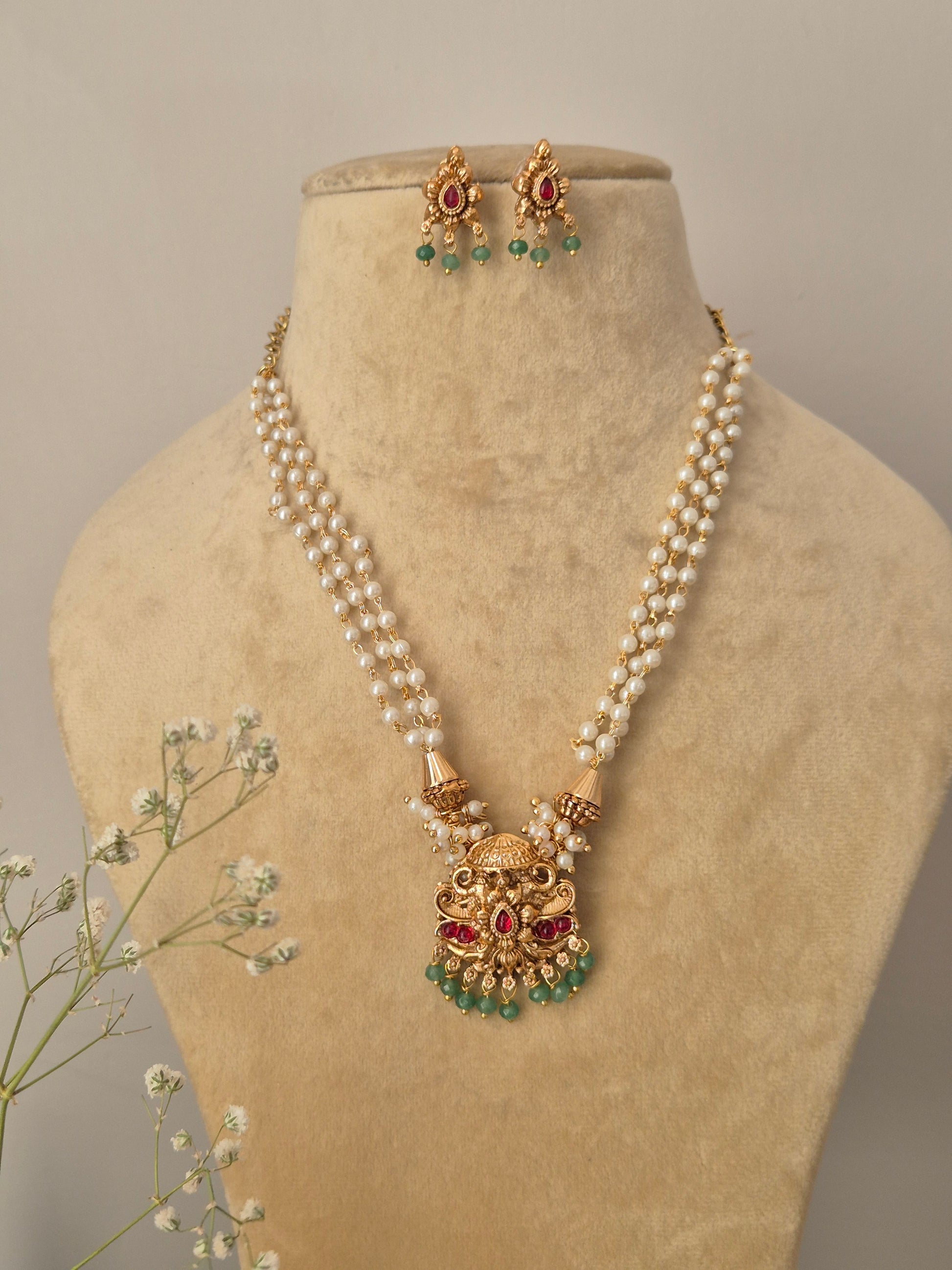 gold-plated pearl chain necklace set with a traditional temple-style pendant and matching drop earrings by naitri.in