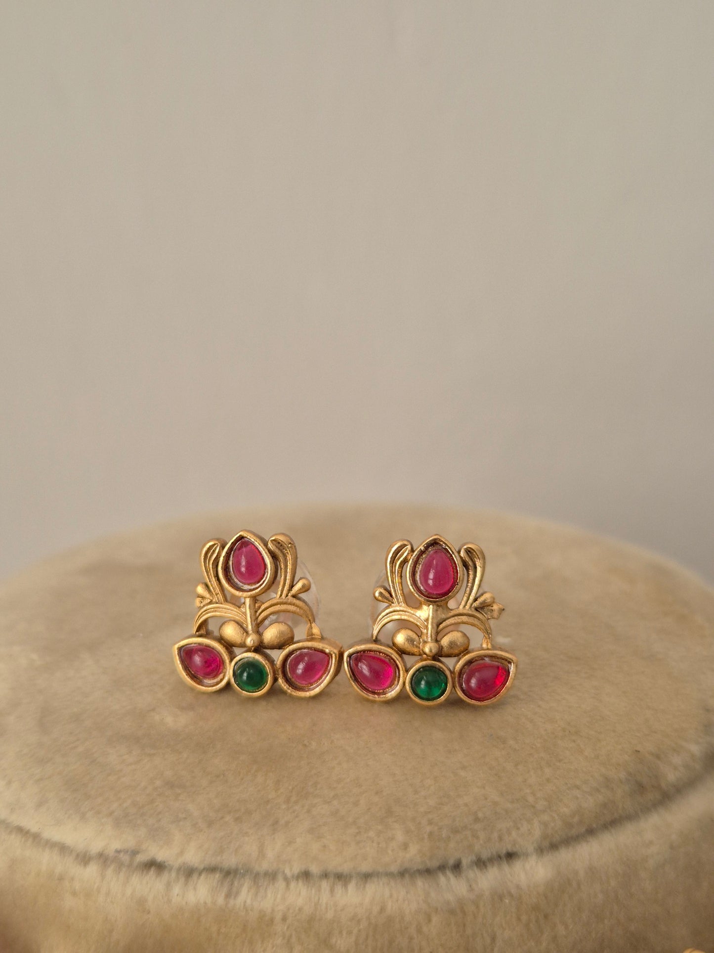 Handcrafted gold earrings with red and green stones by naitri.in