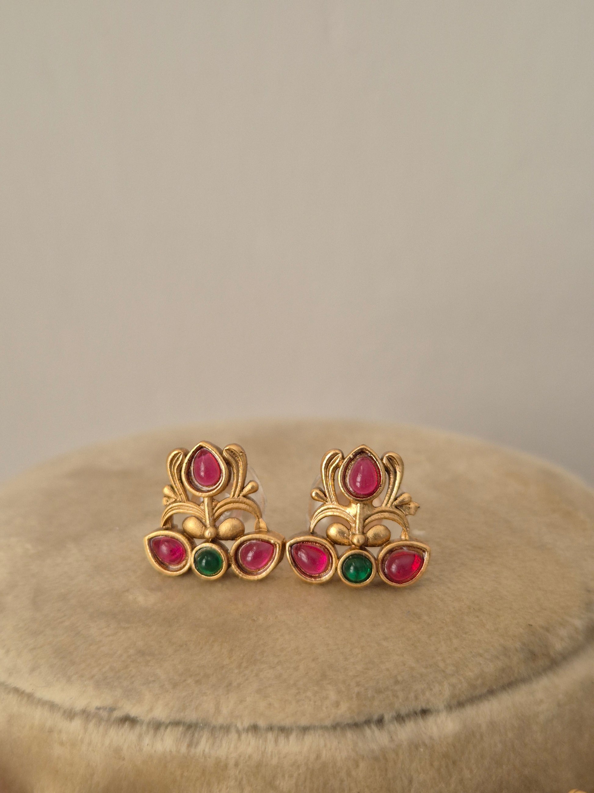 Handcrafted gold earrings with red and green stones by naitri.in