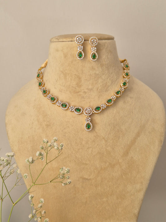 Gold-plated necklace with green teardrop stones and American Diamond accents, including matching drop earrings by naitri.in

