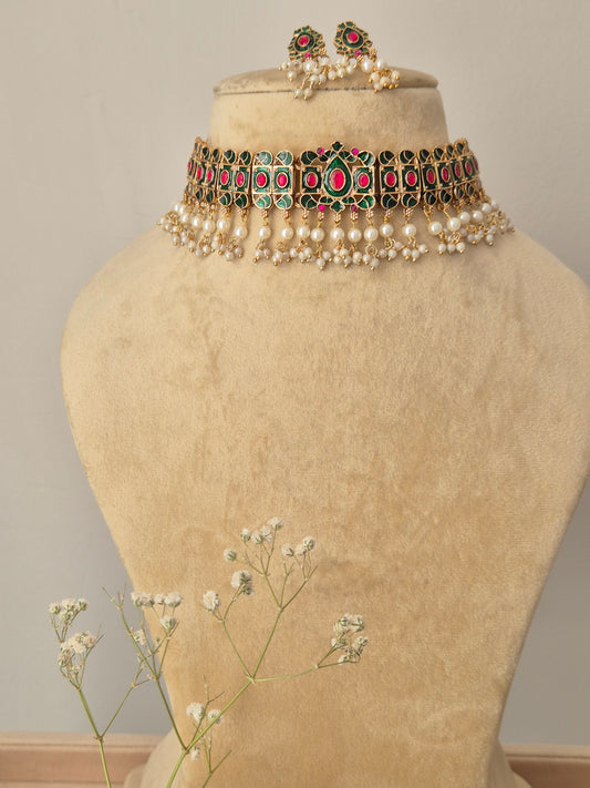 Choker Set with emerald green and ruby pink stones, gold-toned finish, and white pearl droplets by Naitri.in