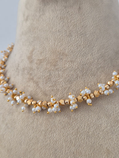 Ornate Designer Floral Necklace and Studs presented on a display bust, emphasizing the delicate petal details, rich golden texture, and timeless cultural appeal by Naitri.in 