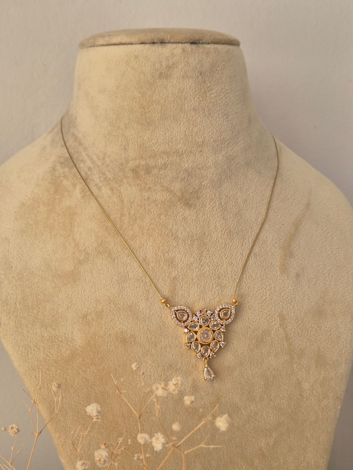 Gold-plated Ruma invisible chain necklace with traditional pendant by Naitri.in