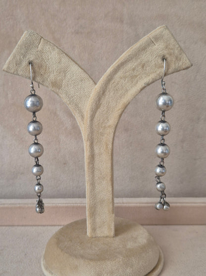 Naitri premium Sabina silver dangle earrings from the modern imitation jewellery collection, Handcrafted silver-plated linear drop earrings with round metallic accents by naitri.in