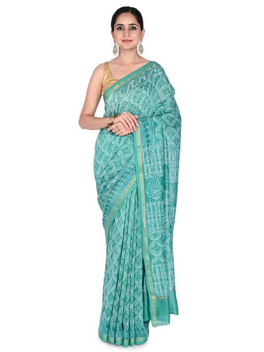 A model wearing the teal green Sadana cotton-silk saree featuring traditional white geometric hand-block prints and a gold zari border, paired with a gold sleeveless blouse by naitri.in