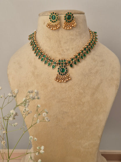 Gold-plated choker necklace featuring intricate green stonework with matching stud earrings by naitri.in