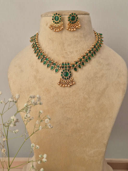 Gold-plated choker necklace featuring intricate green stonework with matching stud earrings by naitri.in