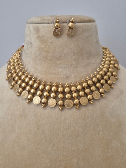The Sapna Necklace Set by Naitri, a brass alloy matte gold choker with coin details and matching earrings by naitri.in