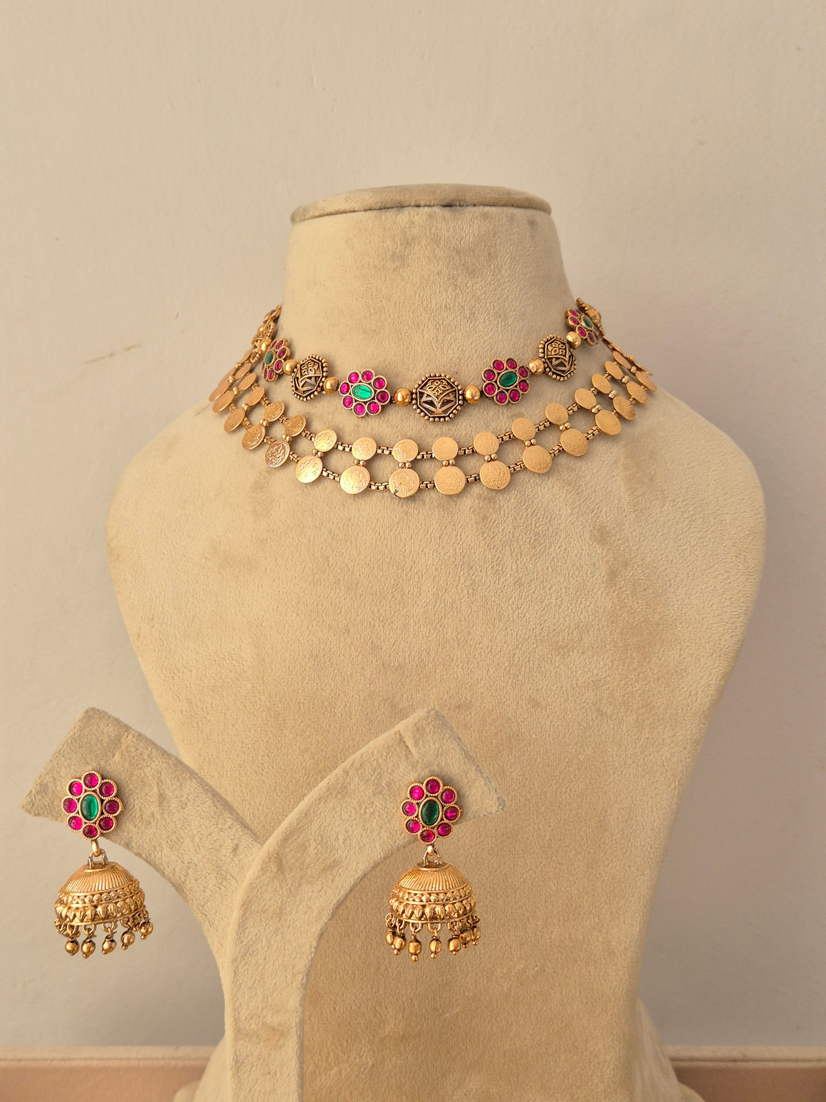 Traditional gold-plated layered choker necklace set with ruby and emerald-colored stone by Naitri.in