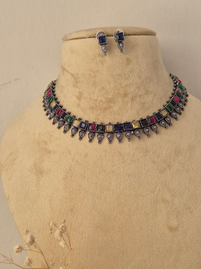 Oxidized silver brass alloy choker necklace set featuring classic Indian motifs and pearl accents by Naitri.in