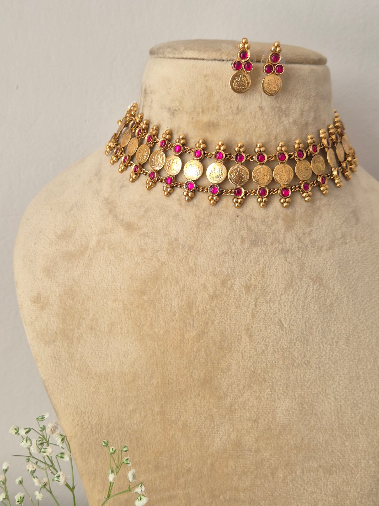 Elegant green gemstone and gold-toned ethnic coin jewelry set, Gold-plated traditional coin choker necklace with red bead drops and matching earrings by naitri.in