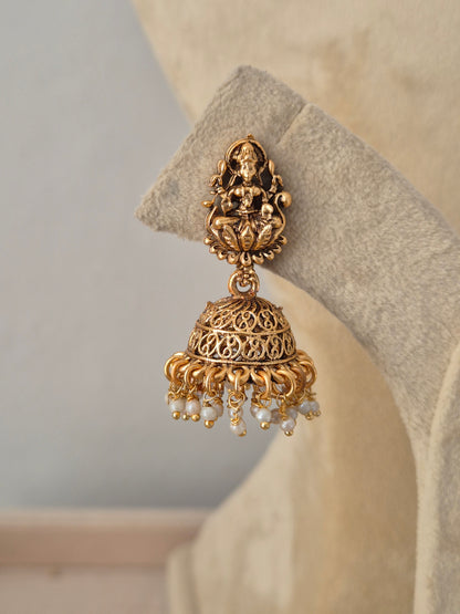 Traditional Indian gold-plated jhumka in antique gold finish featuring deities by Naitri.in