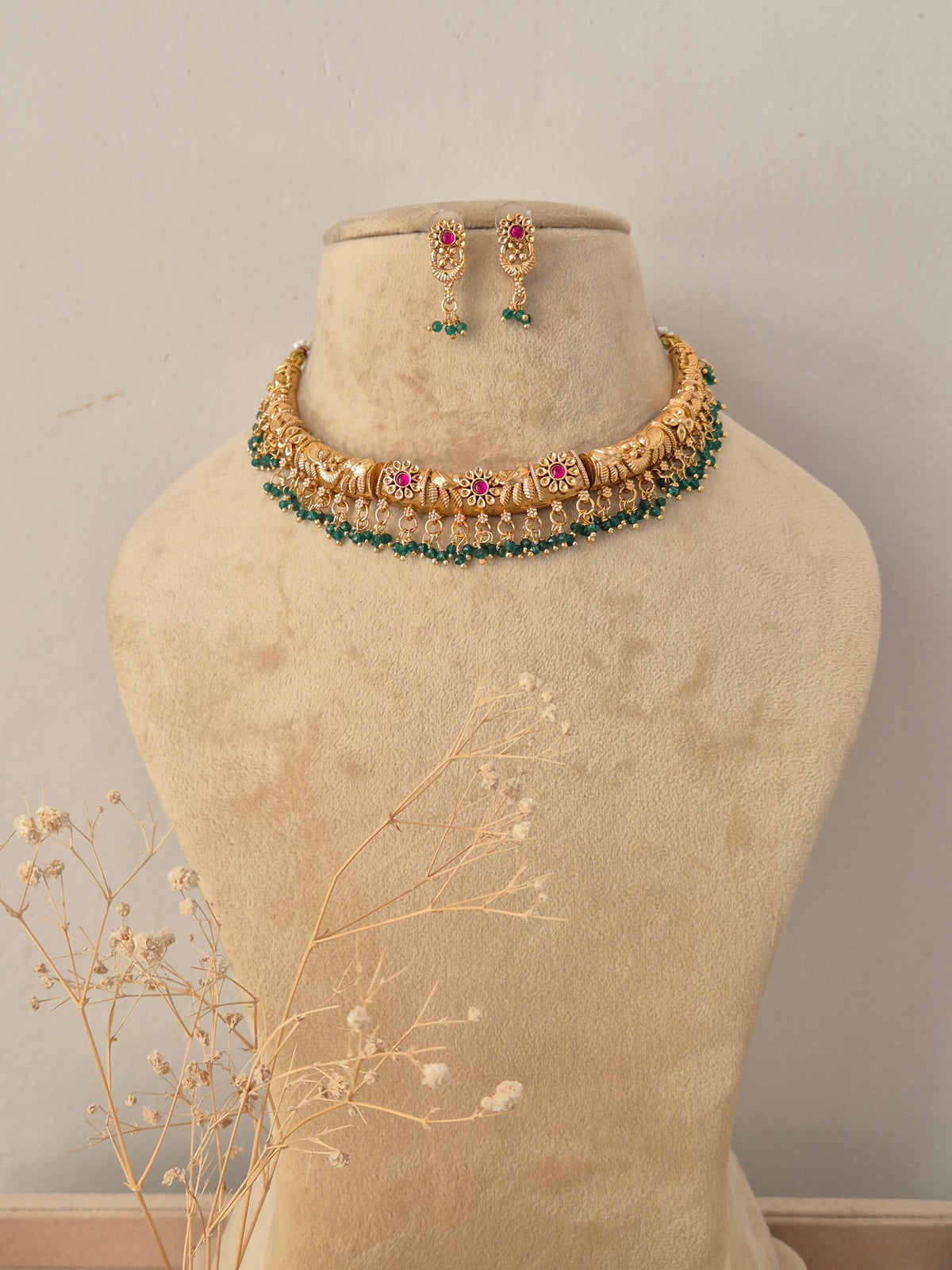 Simmi Necklace Set featuring traditional gold temple motifs with vibrant ruby stone accents and matching earrings by Naitri.in