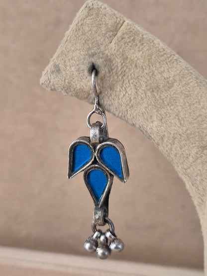 Pair of blue leaf-shaped glass drop earrings with silver bead detail. Sizu  blue glass dangle earrings with silver embellishments by naitri.in
