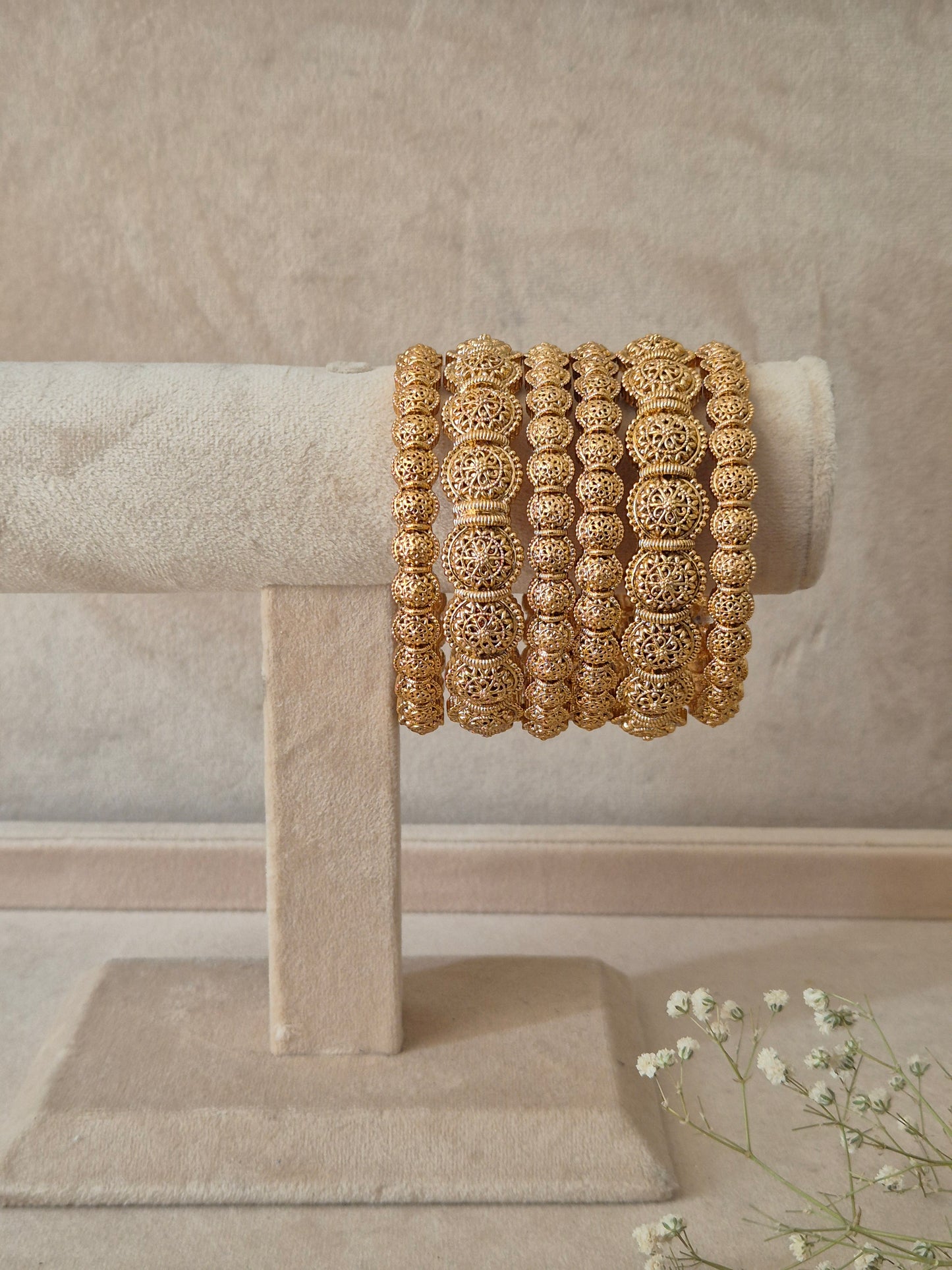 A set of six gold Sona bangles with intricate, textured filigree metalwork, by naitri.in