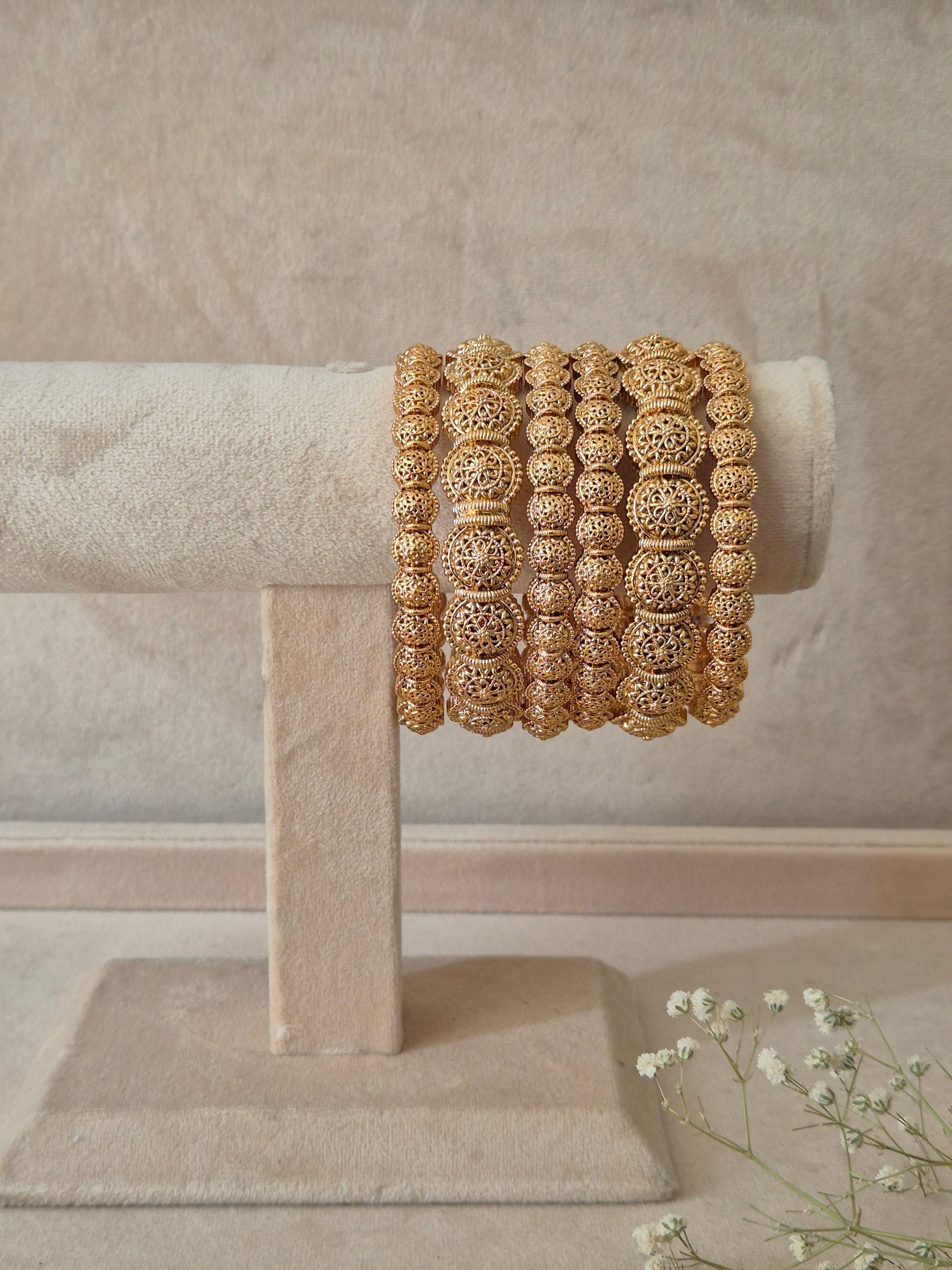 A set of six gold Sona bangles with intricate, textured filigree metalwork, by naitri.in