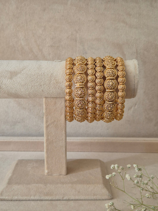 A set of six gold Sona bangles with intricate, textured filigree metalwork, by naitri.in