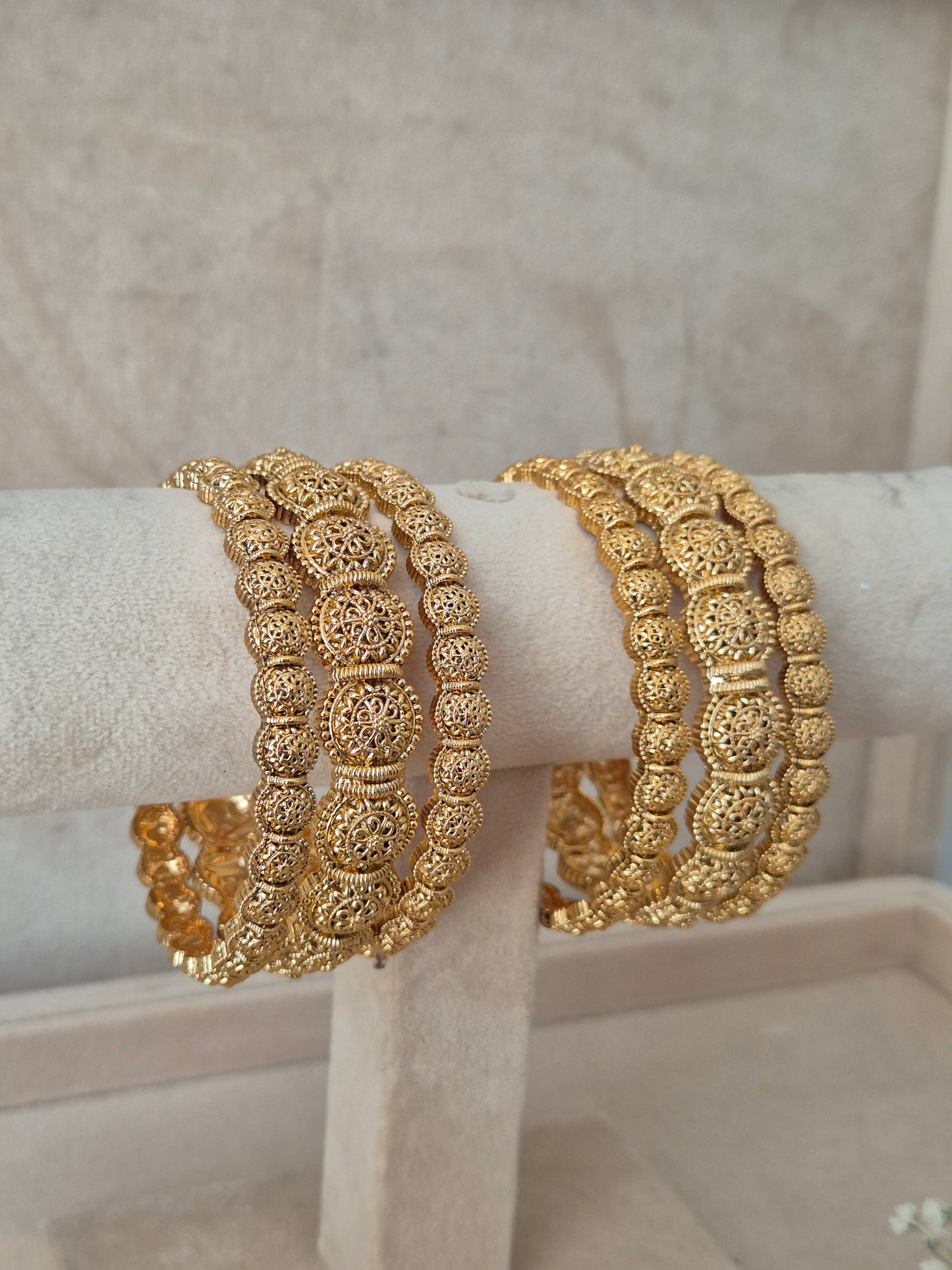 Set of six traditional gold-toned bangles with detailed textured metalwork by naitri.in