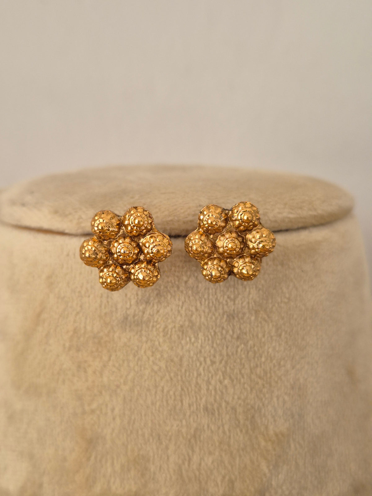 Traditional Indian gold-plated floral stud earrings with an intricate textured cluster design by Naitri.in