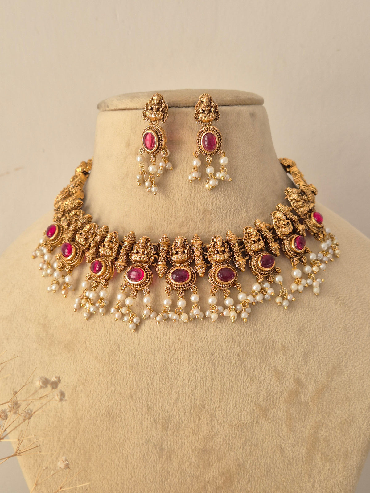 Handcrafted Brass Alloy Ethnic Choker styled against a neutral background, highlighting detailed heritage metalwork, clustered pink stone settings, and classic hanging pearls that add a touch of regal elegance by Naitri.in