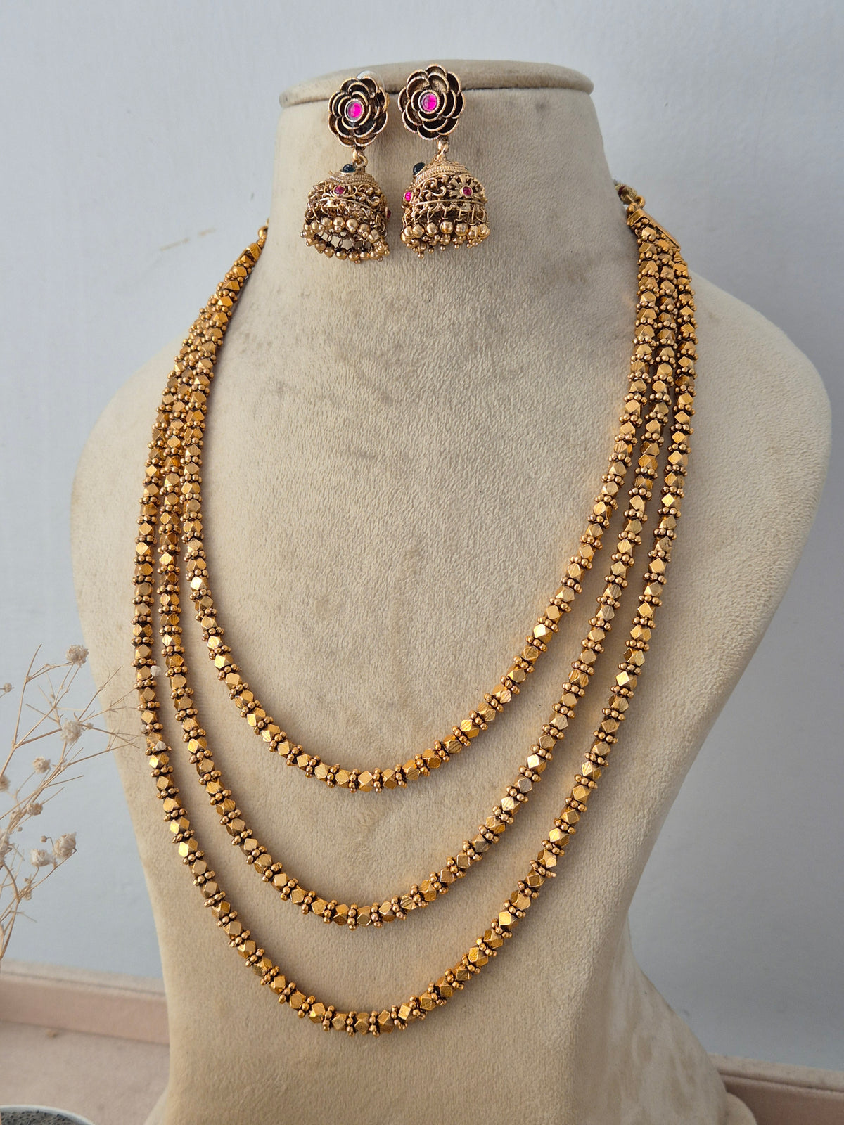 Ornate ethnic fashion jewelry set with a layered chain design, paired with matching jhumka earrings for festive wear by Naitri.in