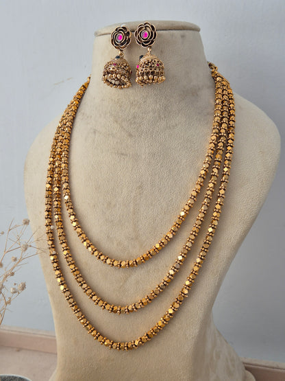 Ornate ethnic fashion jewelry set with a layered chain design, paired with matching jhumka earrings for festive wear by Naitri.in