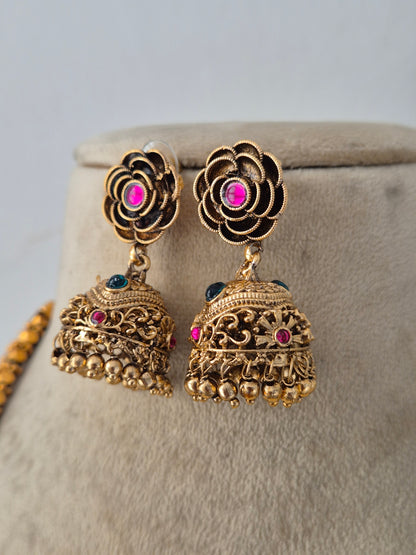 Traditional gold-plated multi-layer bead necklace set displayed on a mannequin with matching jhumka earrings by Naitri.in