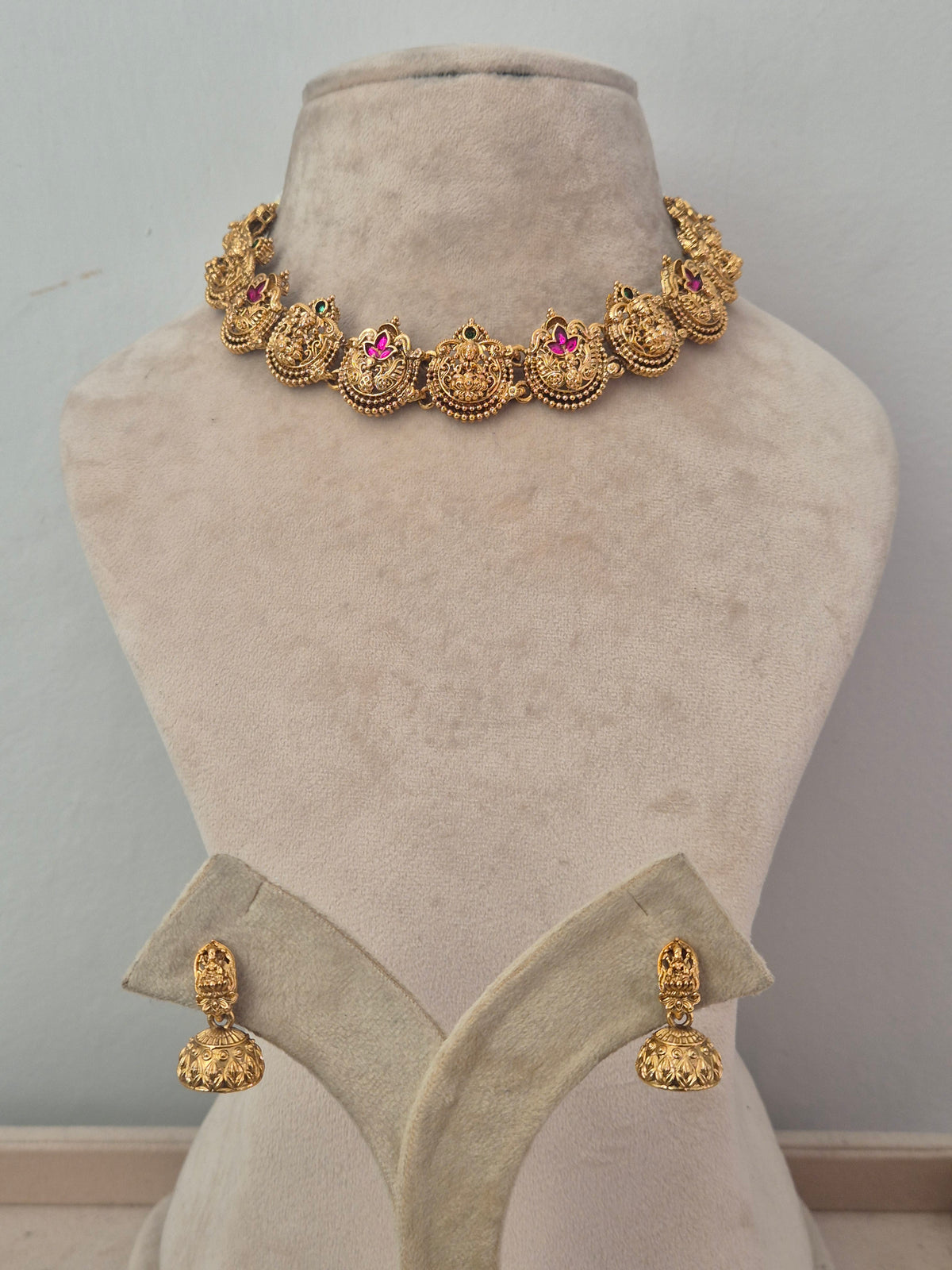 Suchi Necklace Set with Pink and Green Stones | Naitri Ethnic Jewellery. Traditional gold choker necklace  with pink ruby and green stone embellishments by naitri.in