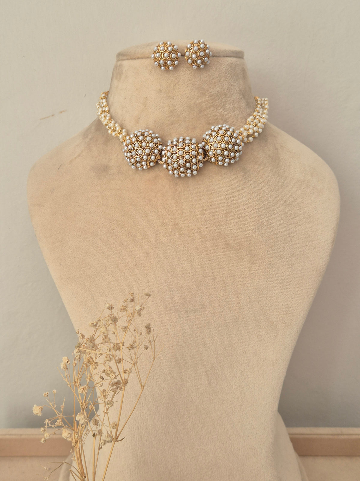 Traditional pearl and gold choker necklace dome-shaped pearl clusters connected by a pearl-embellished band with matching stud earrings by naitri.in
