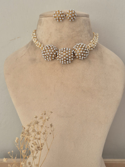 Elegant gold choker necklace featuring dome-shaped pearl clusters connected by a pearl-embellished band, with matching round pearl by naitri.in