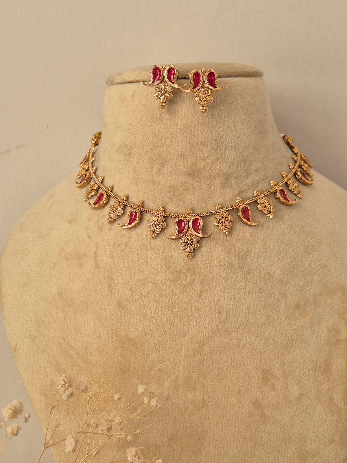 Traditional Indian gold-toned necklace set with floral and crescent metalwork details and red  enamel accents, by naitri.in