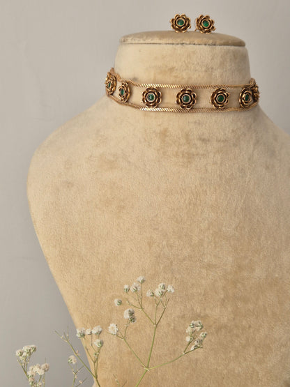 gold and Green Stone Set: An artisanal brass choker with floral detailing and coordinating stud earrings by naitri.in