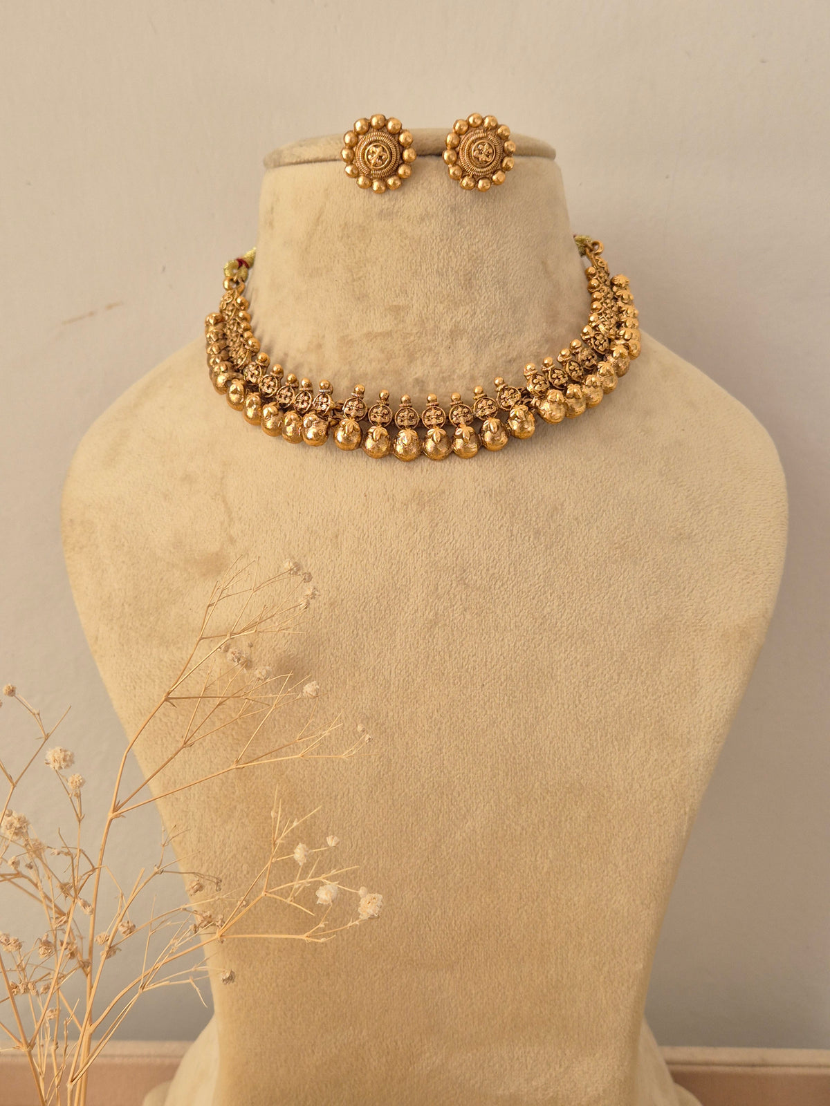 Tanya Necklace Set in antique gold finish displayed on a mannequin with matching stud earrings by Naitri